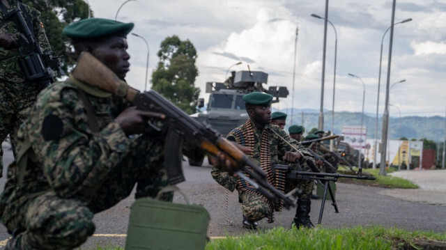 Des membres des Forces de défense du peuple ougandais (UPDF) se positionnent du côté ougandais de la ville frontalière de Bunagana, en République démocratique du Congo, en attendant leur déploiement, le 30 mars 2023. 