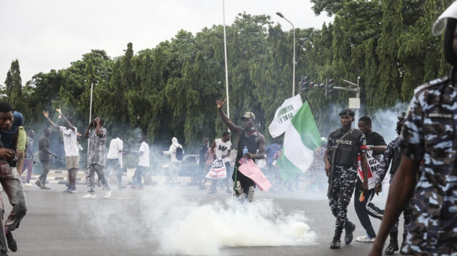 Des manifestants réagissent alors que des policiers nigérians tirent des grenades lacrymogènes lors de la manifestation "End Bad Governance" (Fin de la mauvaise gouvernance) à Abuja, le 1er août 2024. 