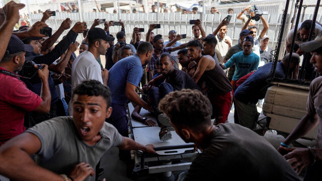 Des Palestiniens utilisant leur téléphone portable pour prendre des photos alors que les victimes des bombardements israéliens sont transportées à l'hôpital Nasser de Khan Yunis, dans le sud de la bande de Gaza, le 7 août 2024, dans le cadre du conflit entre Israël et le groupe militant palestinien Hamas.