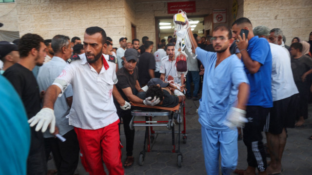 Des médecins palestiniens transportant un homme blessé à la suite d'un bombardement israélien sur Deir el-Balah à l'hôpital des Martyrs d'Al-Aqsa dans le centre de la bande de Gaza, le 6 août 2024, dans le cadre du conflit actuel entre Israël et le groupe palestinien Hamas.
