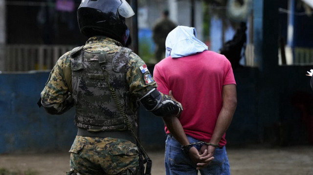 Un agent de la police des frontières panaméenne arrête un homme lors d'une opération de lutte contre le trafic de migrants près de Santa Fe, dans la province de Darien, au Panama, le 7 août 2024.