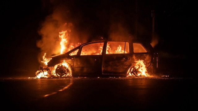 Voiture en feu sur la route principale de la Rivière Salée à Nouméa, dans le territoire d'outre-mer français de Nouvelle-Calédonie, le 24 juin 2024.