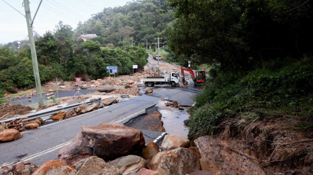 Des ouvriers dégagent des rochers et des pierres après qu'un glissement de terrain a coupé Lawrence Hargrave Drive à Coalcliff à Wollongong en Australie, le 6 avril 2024.