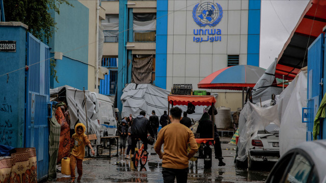 Des Palestiniens marchant à l'entrée d'une école de l'UNWRA utilisée comme abri dans la ville de Gaza, le 27 novembre 2023. 