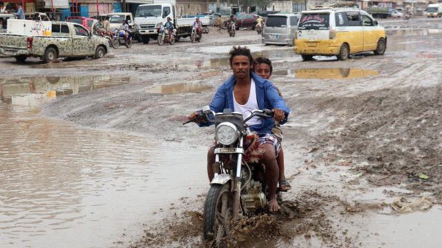 Un homme conduit une moto dans une rue boueuse suite à de fortes inondations dans la région de Hays, au sud du gouvernorat de Hodeidah au Yémen, le 21 août 2024. 