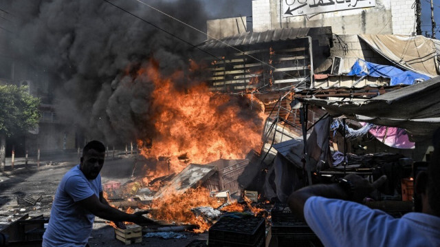 Un Palestinien réagit alors qu'un incendie se déclare dans un marché de fruits dans la ville de Jénine, en Cisjordanie occupée, pendant les raids israéliens du 31 août 2024.