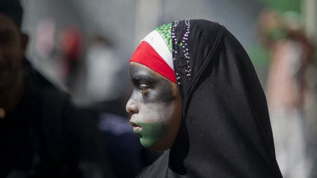 Une jeune fille, portant un hijab et le visage peint aux couleurs du drapeau palestinien, participe à une marche de protestation contre l'action militaire d'Israël à Gaza et de soutien au peuple palestinien, au Cap, le 9 août 2014.