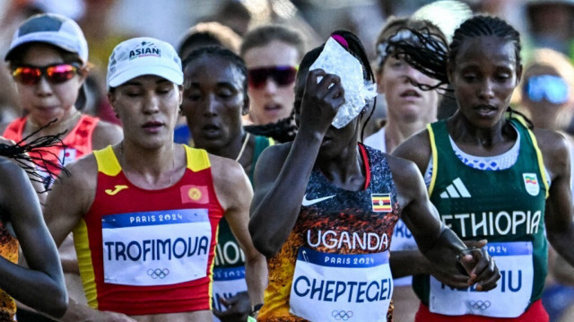 Rebecca Cheptegei de l'Ouganda applique un sac de glace sur sa tête lors du marathon féminin de l'événement d'athlétisme aux Jeux Olympiques de Paris 2024 à Paris le 11 août 2024.