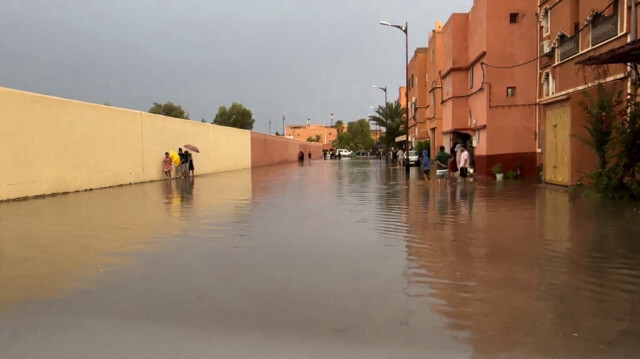 Des habitants marchent dans une rue inondée de la ville de Ouarzazate, au Maroc, le 7 septembre 2024. 