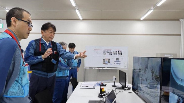 Des membres du personnel de TEPCO en train de vérifier dans la salle des opérations que les tuyaux de poussée utilisés pour l'enlèvement des débris radioactifs sont réarrangés dans le bon ordre, à la centrale nucléaire de Fukushima Daiichi de TEPCO à Okuma, dans la préfecture de Fukushima, le 10 septembre 2024.