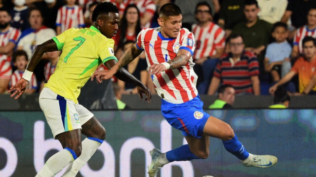 L'attaquant brésilien Vinicius Jr (G) et le défenseur paraguayen Junior Alonso lors du match de qualification sud-américain pour la Coupe du monde de la FIFA 2026 entre le Paraguay et le Brésil, à Asuncion, le 10 septembre 2024. 