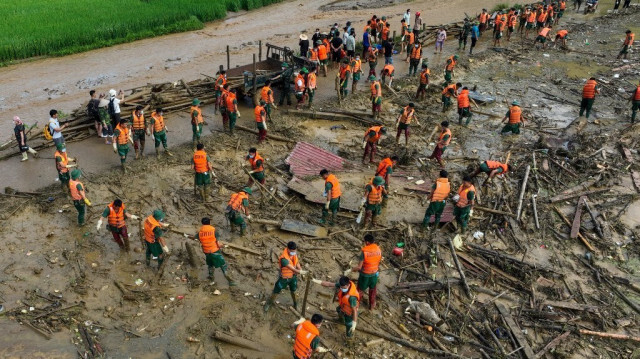 Des secouristes examinent les débris sur le site d'un glissement de terrain dans le village montagneux isolé de Lang Nu, dans la province de Lao Cai, le 12 septembre 2024, à la suite du typhon Yagi qui a frappé le nord du Viêt Nam.