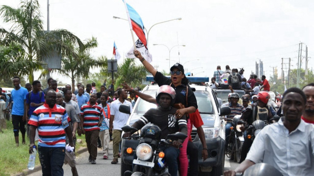 Des partisans du parti Chadema accueillent Tundu Lissu (non visible), figure emblématique de l'opposition tanzanienne, à son retour après environ cinq ans d'exil, à l'aéroport international Julius Nyerere de Dar es Salaam, le 25 janvier 2023. 