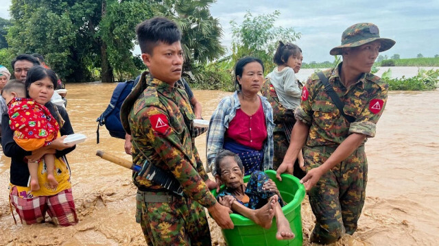 Des militaires aident des habitants à traverser les eaux de crue à Pyinmana, dans la région de Naypyidaw, au Myanmar, le 13 septembre 2024, à la suite des fortes pluies provoquées par le typhon Yagi.