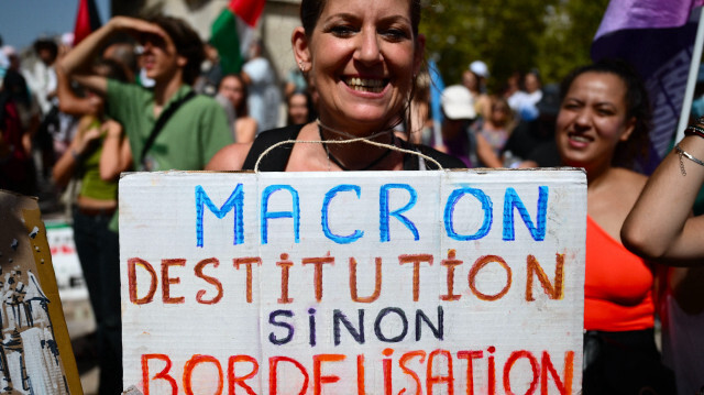 Une manifestant etient une pancarte sur laquelle on peut lire "Macron la destitution ou la bordelisation". Elle participe à une manifestation contre la nomination du Premier ministre de droite Michel Barnier par le président français Emmanuel Macron à Marseille, dans le sud de la France, le 7 septembre 2024. Des manifestations nationales sont organisées le 7 septembre, sous l'égide de dirigeants politiques de la coalition des partis de gauche français et de syndicats, pour dénoncer le fait que le président français n'a pas nommé de premier ministre de gauche après avoir pris le risque de dissoudre le parlement en juin et d'organiser des élections anticipées en juillet, au cours desquelles son alliance centriste a perdu la majorité relative dont elle disposait au parlement.