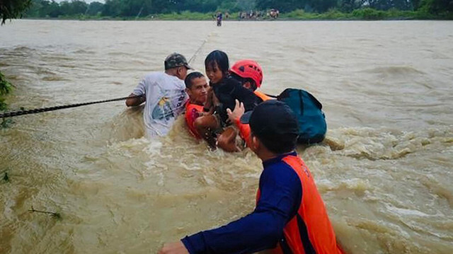 Des gardes-côtes philippins (PCG) et les secouristes évacuant les résidents suite aux fortes pluies qui ont provoqué des inondations causées par la tempête tropicale Bebinca dans la ville de Rizal, dans la province de Mindoro Occidental, le 15 septembre.