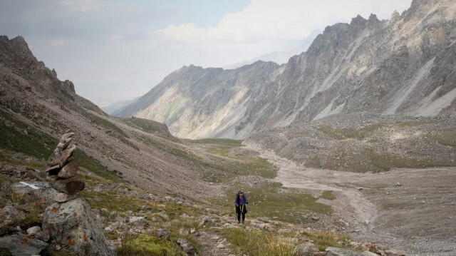 La glaciologue Goulbara Omorova marche vers le glacier Adygene dans la chaîne de montagnes du Tian Shan le 7 juillet 2024.