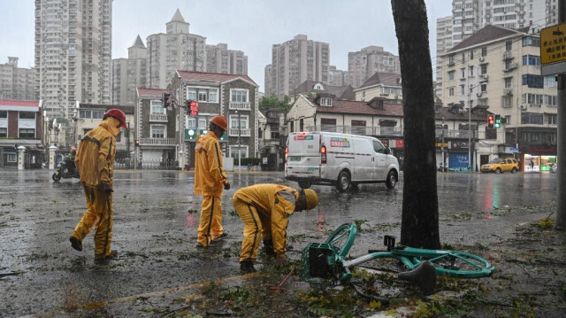 Des ouvriers enlèvent les débris des routes alors que des vents violents et des pluies torrentielles se sont abattus sur Shanghai après le passage du typhon Bebinca, le 16 septembre 2024.