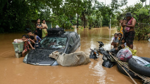 Des habitants touchés par les inondations attendent l'arrivée d'un bateau de secours à Taungoo, dans la région de Bago, au Myanmar, le 14 septembre 2024, après les fortes pluies qui ont suivi le passage du typhon Yagi. 