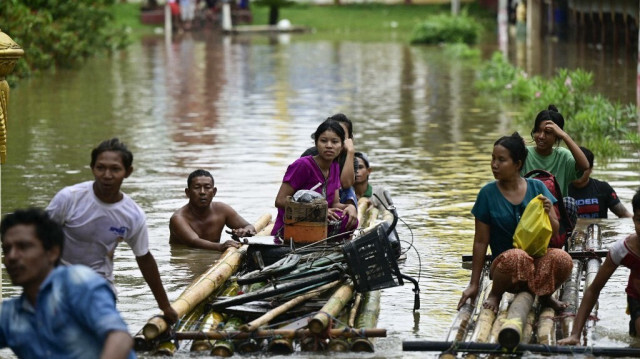 Des habitants touchés par les inondations utilisent des radeaux de bambou pour rejoindre un terrain plus élevé à Taungoo, dans la région de Bago, au Myanmar, le 14 septembre 2024, à la suite des fortes pluies qui ont suivi le passage du typhon Yagi.