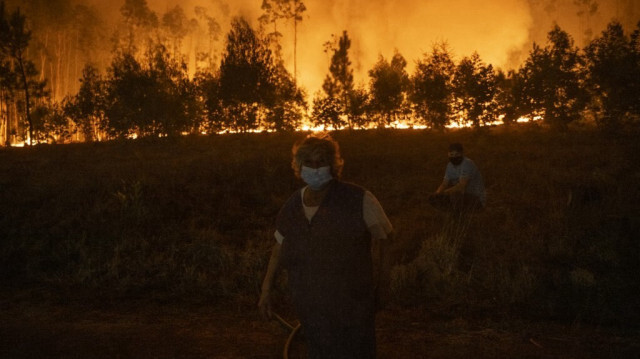 Les habitants observent la progression d'un incendie de forêt dans le village de Veiga à Agueda, Aveiro, le 17 septembre 2024.