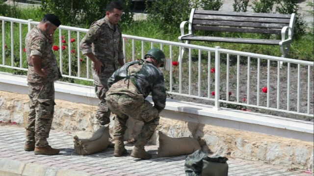 Les forces de l'armée libanaise se préparant à détruire, par une explosion contrôlée, un appareil de communication trouvé au sol dans le sud du Liban, le 19 septembre 2024.