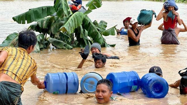 Des habitants pataugent dans les eaux de crue à Pyinmana, dans la région de Naypyidaw, au Myanmar, le 13 septembre 2024, à la suite des fortes pluies provoquées par le typhon Yagi.