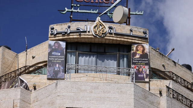 Les photos de la journaliste d'Al-Jazeera Shireen Abu Akleh sont accrochées à la façade du bâtiment abritant les bureaux de la chaîne de télévision à Ramallah, en Cisjordanie occupée, après qu'Israël a émis un ordre de fermeture de 45 jours le 22 septembre 2024.