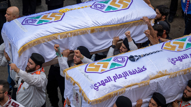 Des scouts portent les cercueils de deux enfants, Hassan et Amira Muhammed Fadallah, lors de leurs funérailles, un jour après qu'ils aient été tués lors d'une frappe israélienne sur un bâtiment dans la banlieue sud de Beyrouth, le 31 juillet 2024. 