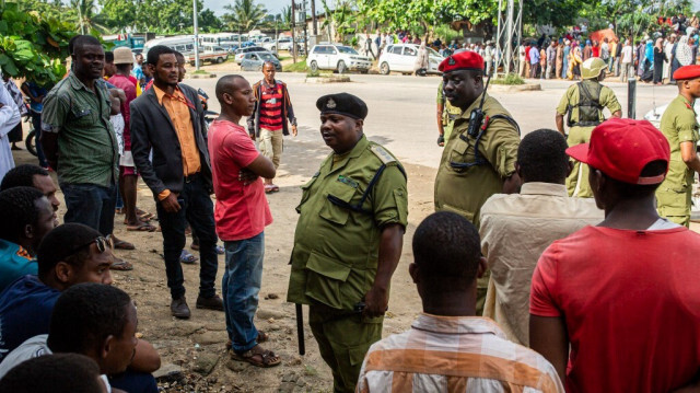 Un officier de police tanzanien s'entretient avec des personnes devant le bureau de vote de Garagara Playground à Mtoni, Zanzibar, le 28 octobre 2020. 