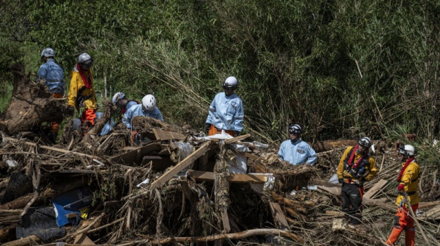 Le personnel de secours recherche des personnes disparues dans les débris emportés par les inondations le long de la rivière Tsukada à la suite de fortes pluies dans la ville de Wajima, préfecture d'Ishikawa, le 23 septembre 2024.