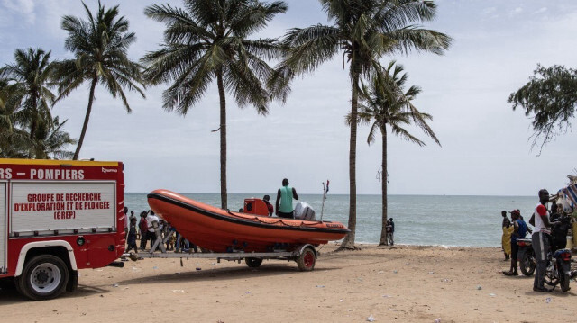 Des membres d'une équipe de recherche et de sauvetage quittent la plage après avoir cherché des survivants et récupéré les morts après le naufrage d'une pirogue transportant plus d'une centaine de migrants la nuit précédente, à Mbour au Sénégal. 