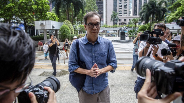 Chung Pui-kuen (C), l'ancien rédacteur en chef du média pro-démocratique Stand News, aujourd'hui fermé à Hong Kong, arrive au tribunal de district de Hong Kong le 26 septembre 2024 pour le prononcé de sa peine après avoir été reconnu coupable, fin août 2024, de conspiration en vue de publier des ouvrages séditieux.