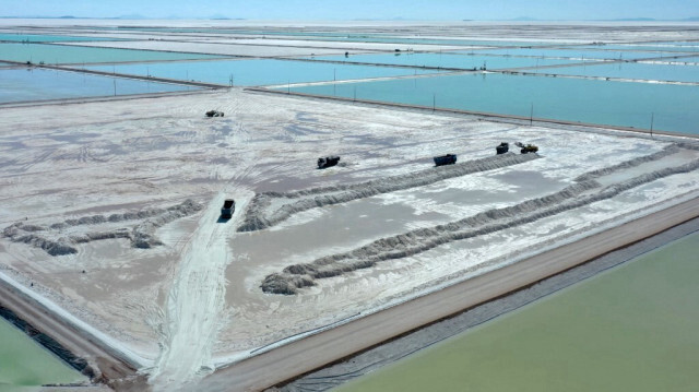 Des camions chargeant de la saumure depuis les bassins d'évaporation du nouveau complexe public d'extraction de lithium, dans la zone sud du salar d'Uyuni, en Bolivie.