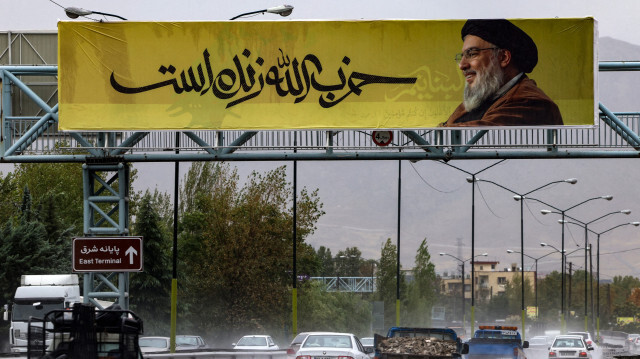 Une grande banderole portant une photo du chef du Hezbollah libanais, Hassan Nasrallah, avec l'inscription en farsi "Le Hezbollah est vivant" est suspendue le long d'un pont dans le nord de Téhéran, le 28 septembre 2024. L'armée israélienne a déclaré le 28 septembre que la lutte contre le Hezbollah n'était pas terminée après avoir annoncé l'assassinat de Hassan Nasrallah, le chef du groupe.