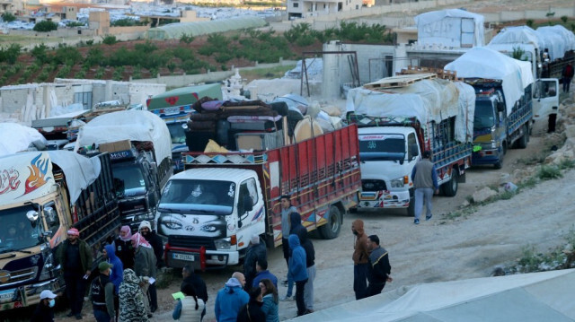 Des réfugiés syriens se tiennent près de camions transportant leurs biens alors qu'ils se préparent à quitter le Liban pour retourner en Syrie, à Arsal dans la vallée de la Bekaa, le 14 mai 2024. 