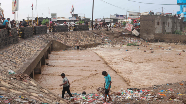 Des enfants marchent à côté d'un pont inondé après les récentes pluies torrentielles qui ont frappé la région d'al-Khokha, à l'ouest du Yémen, le 1er septembre 2024.