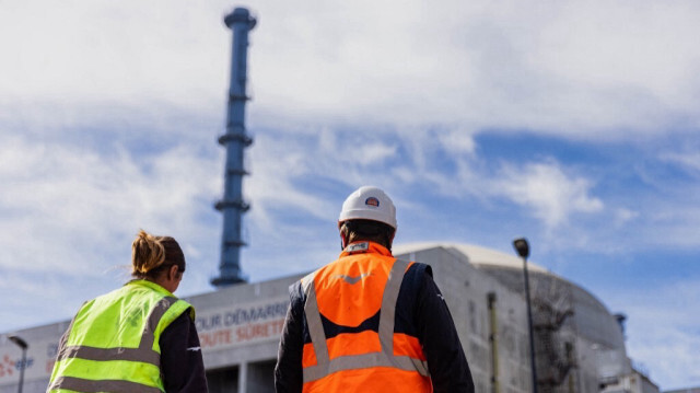 Des ouvriers devant le bâtiment du réacteur de la troisième génération du projet de réacteur pressurisé européen (EPR) de Flamanville, en Normandie, le 14 juin 2022.