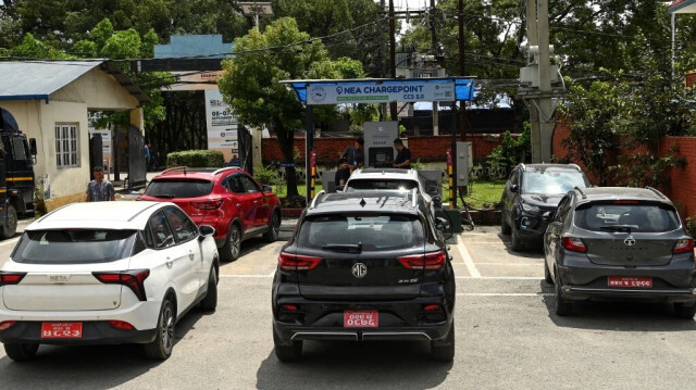 Des personnes rechargent leurs véhicules électriques à une station de recharge à Katmandou, capitale du Népal, le 5 septembre 2024.