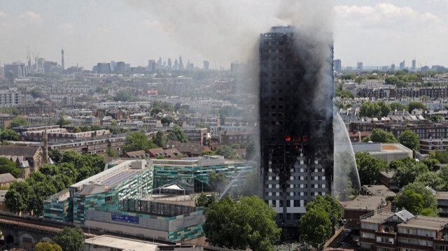 De la fumée et des flammes s'échappent de la Grenfell Tower alors que les pompiers tentent de maîtriser l'incendie qui ravage cet immeuble résidentiel dans l'ouest de Londres, le 14 juin 2017.