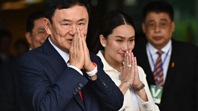 L'ancien premier ministre thaïlandais Thaksin Shinawatra salue ses partisans en compagnie de sa fille cadette Paetongtarn Shinawatra (à droite), surnommée "Ung Ing", la nouvelle Première ministre.