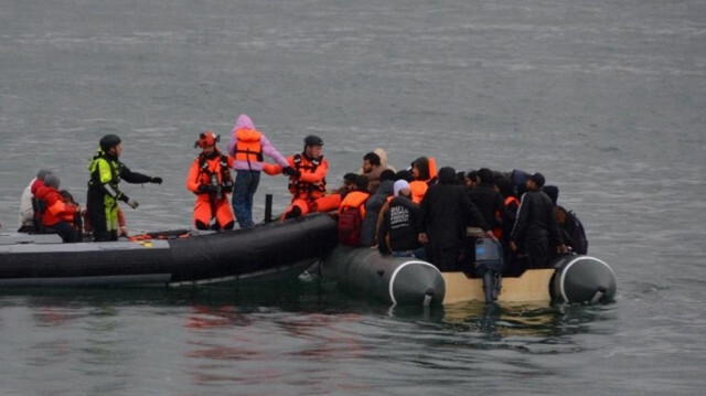 Des sauveteurs assistent des migrants à bord d'un canot pneumatique dans la Manche, le 12 juillet 2024.