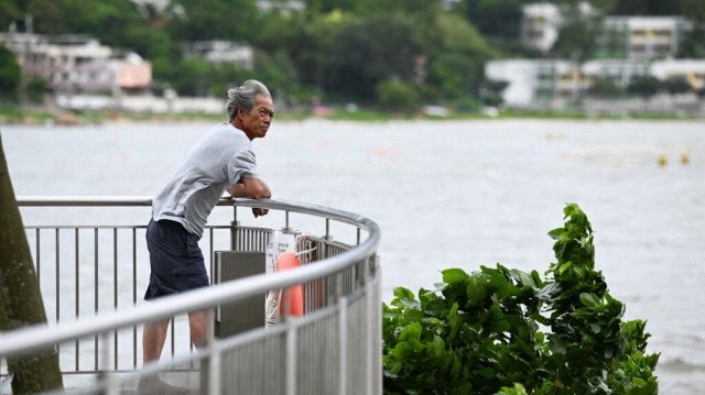 Un homme regarde le vent sur l'île de Lantau à Hong Kong le 6 septembre 2024, après que le super typhon Yagi se soit déplacé vers la province insulaire chinoise de Hainan, laissant Hong Kong indemne.