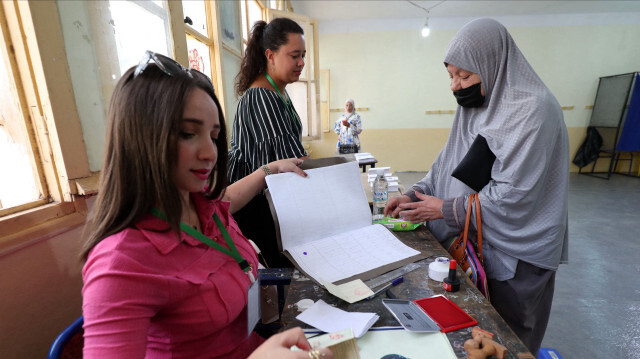 Des agents électoraux algériens vérifient l'identité d'un électeur dans un bureau de vote lors de l'élection présidentielle à Alger, le 7 septembre 2024. Environ 24 millions d'Algériens s'apprêtent à se rendre aux urnes le 7 septembre pour un scrutin au cours duquel les experts estiment que le président sortant Abdelmadjid Tebboune n'est pas exposé à un risque réel pour son mandat.