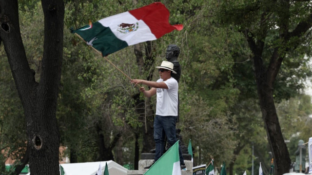 Un homme brandit un drapeau mexicain lors d'une manifestation contre la réforme judiciaire proposée par le gouvernement, à Mexico, le 8 septembre 2024.
