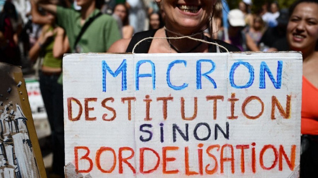 Une manifestante tient une pancarte lors de la protestation contre la nomination du Premier ministre de droite Michel Barnier par le président français Emmanuel Macron à Marseille, dans le sud de la France, le 7 septembre 2024.