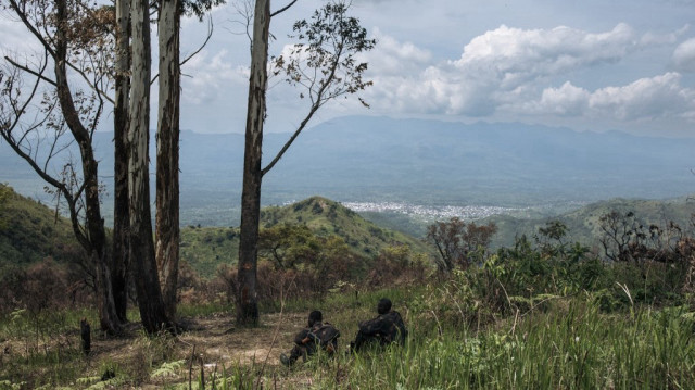 Deux soldats des FARDC (Forces armées de la République Démocratique du Congo) se reposent à l'ombre, à une position militaire en première ligne au-dessus de la ville de Kibirizi, contrôlée par la rébellion M23, dans la province du Nord-Kivu, à l'est de la République Démocratique du Congo, le 14 mai 2024.