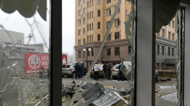 Des personnes se tiennent près d'un magasin endommagé à la suite d'un bombardement, que les autorités locales ont qualifié d'attaque militaire ukrainienne, à Donetsk, en Ukraine contrôlée par la Russie, le 10 janvier 2025, dans le cadre du conflit russo-ukrainien en cours.