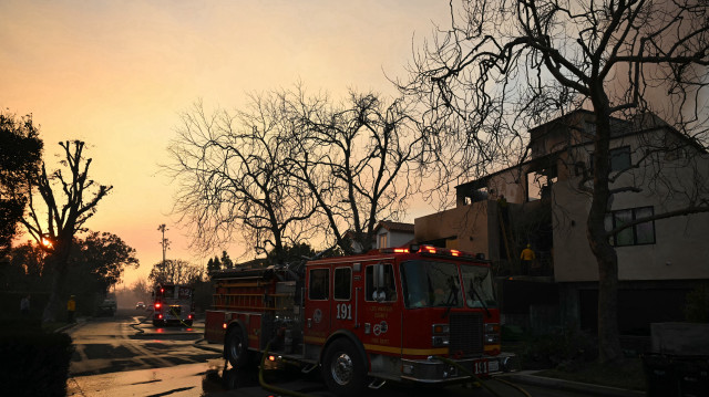 Des pompiers utilisent un tuyau d'arrosage pour éteindre les braises dans une maison lors de l'incendie de Palisades à Pacific Palisades, un quartier de Los Angeles, Californie, le 9 janvier 2025. Les deux plus grands incendies de Los Angeles restent contenus à "zéro pour cent" le 9 janvier malgré les opérations de lutte contre les incendies, ont déclaré les autorités, qui ont également promis de s'attaquer au pillage des maisons évacuées. Un incendie de 6 900 hectares à Pacific Palisades est devenu "l'une des catastrophes naturelles les plus destructrices de l'histoire de Los Angeles", a déclaré le chef des pompiers de la ville, Kristin Crowley, tandis qu'un incendie de 10 000 hectares à Altadena était également à "zéro pour cent de confinement", a déclaré le chef des pompiers du comté, Anthony Marrone.