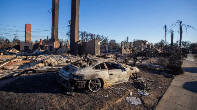 Une voiture et des maisons incendiées par le Palisades Fire le 12 janvier 2025, à Los Angeles, Californie.